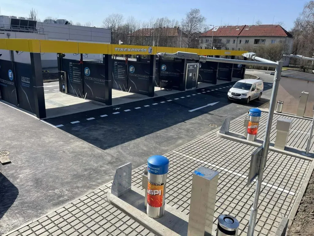 Pohled na dokončenou automyčku TIXEXPRESS s asfaltovým průjezdem a dlážděnou plochou u vysavačů